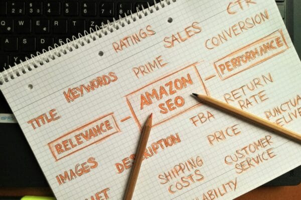 ai seo services - Notebook with handwritten Amazon SEO strategy topics highlighted on a keyboard.