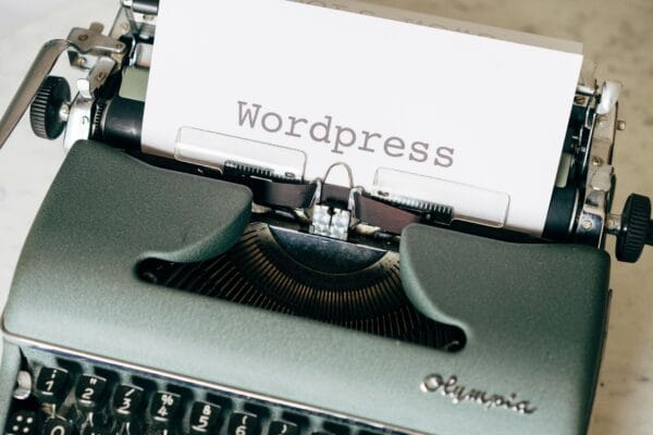 seo plugin wordpress - Close-up of a vintage typewriter with a paper displaying 'Wordpress' in retro style.