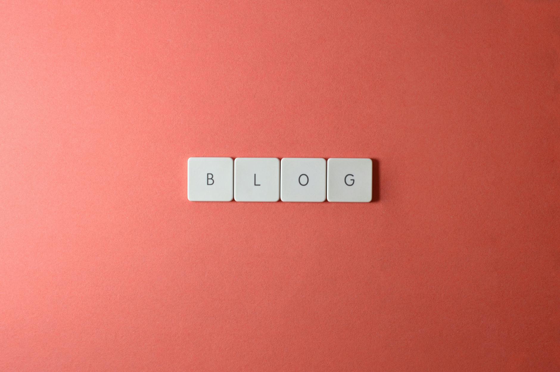 AI untuk konten blog - A minimalist image of keyboard keys spelling 'BLOG' on a coral background.