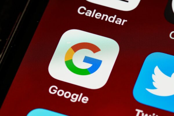 AI dalam SEO - Macro view of a smartphone displaying Google and other app icons on the home screen.