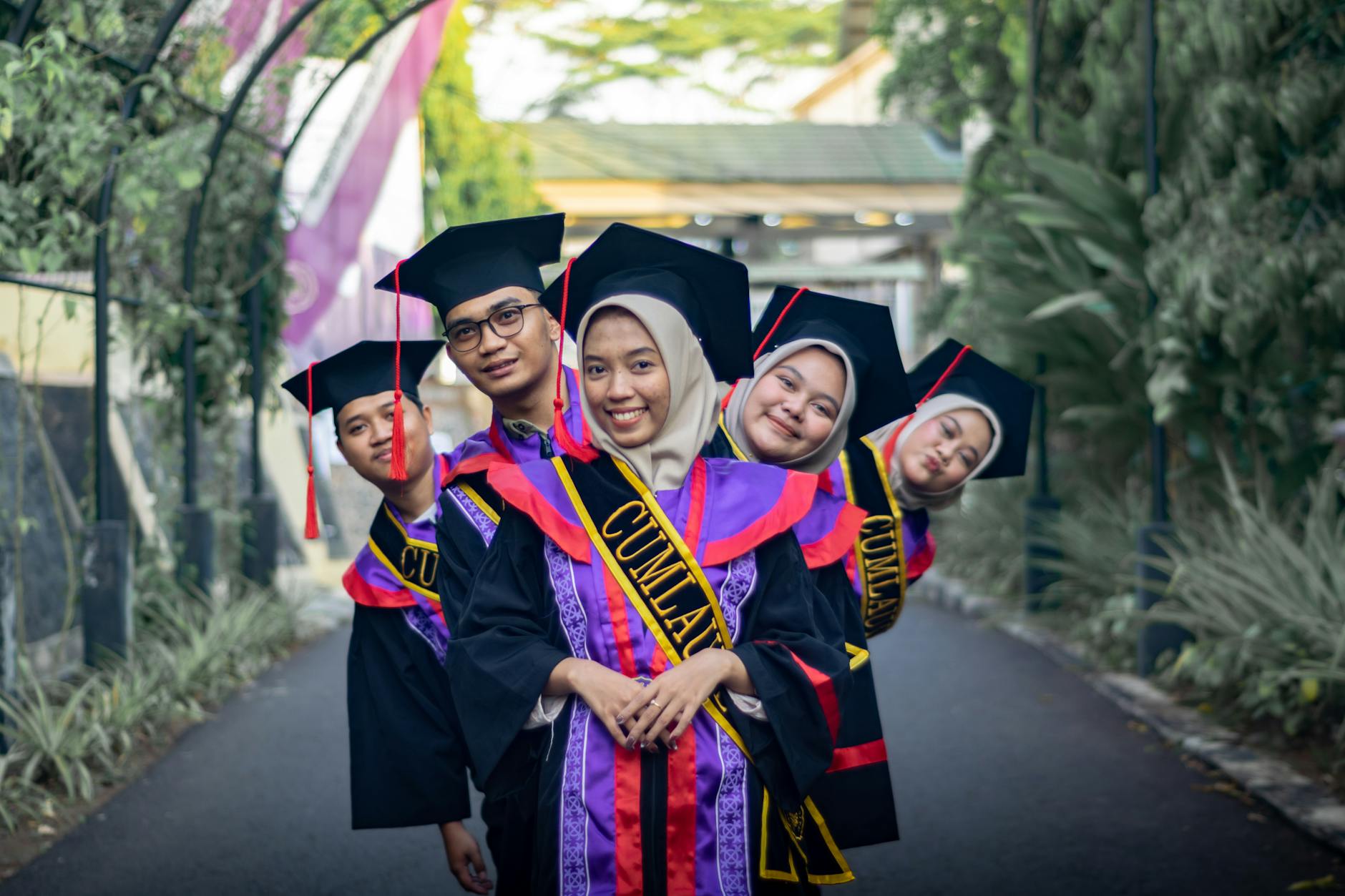 dampak CLS ke UX - Joyful graduates in caps and gowns celebrating their success outdoors.