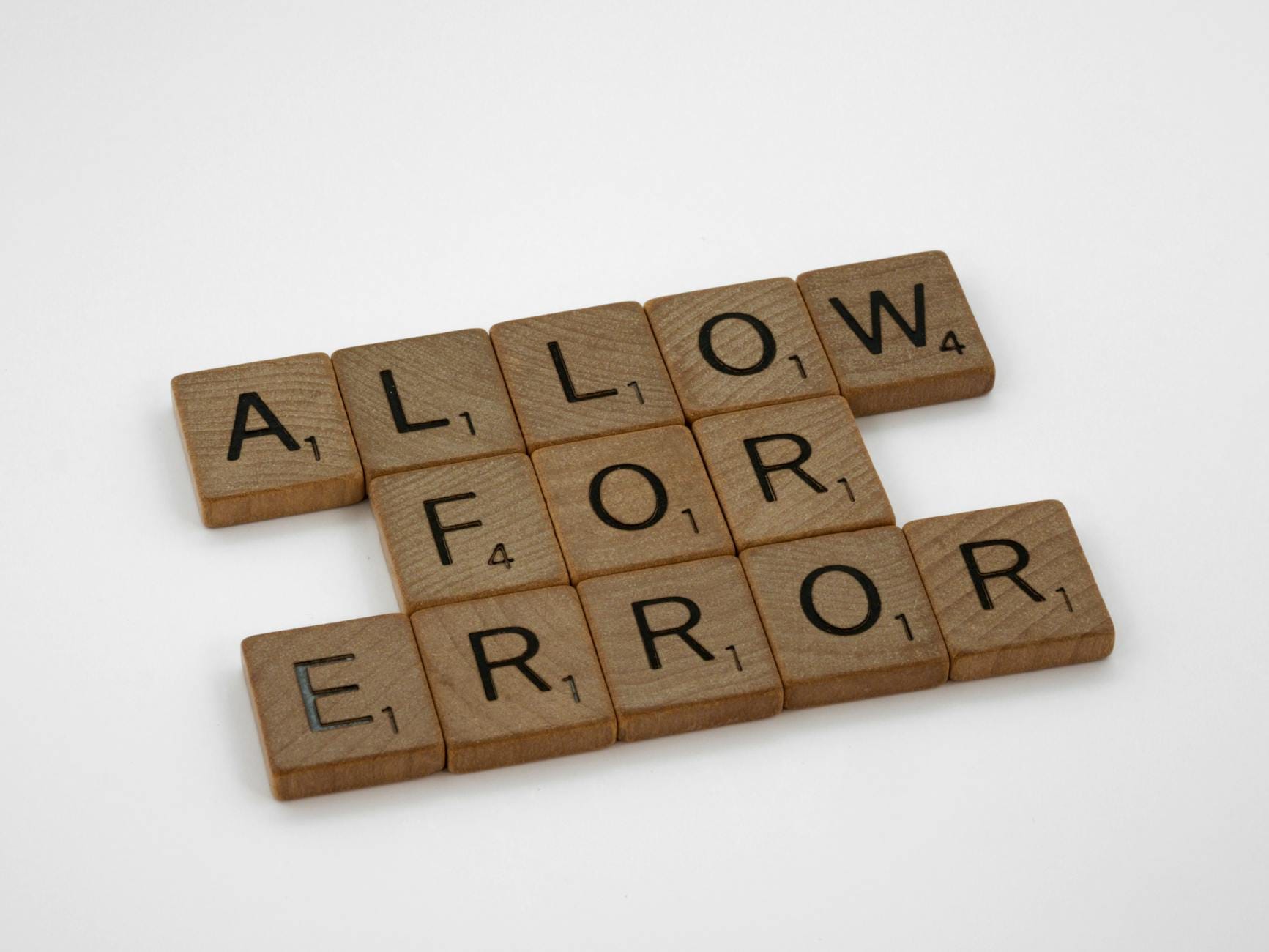 mengatasi crawl error - Wooden Scrabble tiles spelling 'Allow for Error' on a white surface.