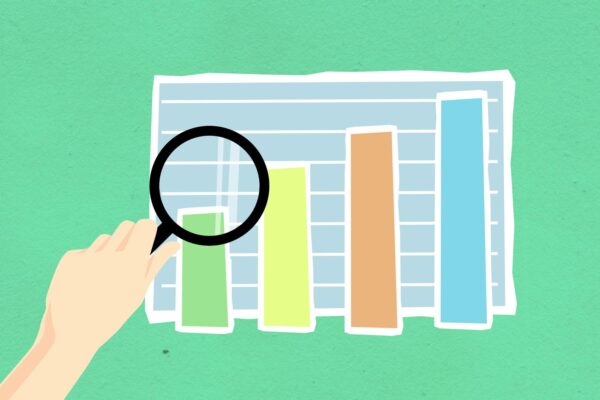 optimasi SEO e-commerce - From above of decorative cardboard appliques of human hand with magnifying glass above diagram on green background