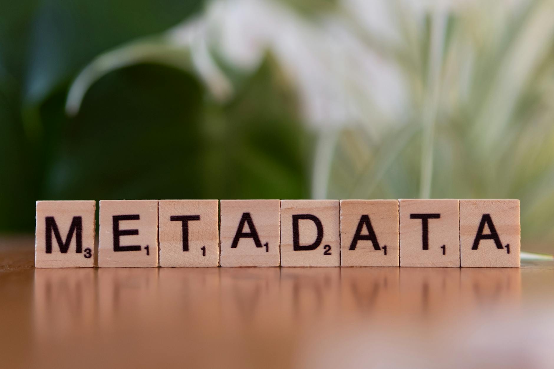 meta description - Close-up of the word 'metadata' spelled out with wooden Scrabble tiles on a table.
