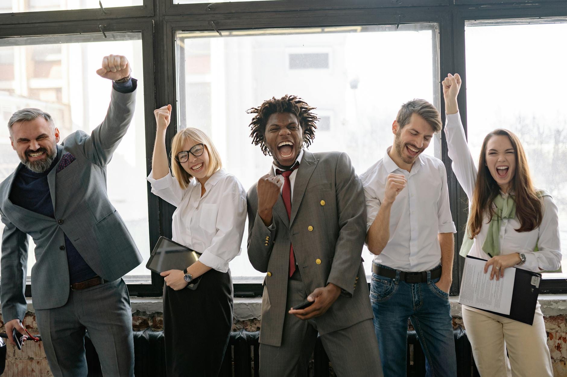 redirect 301 dan 302 - A joyful, diverse group of colleagues celebrating success indoors with cheerful expressions.