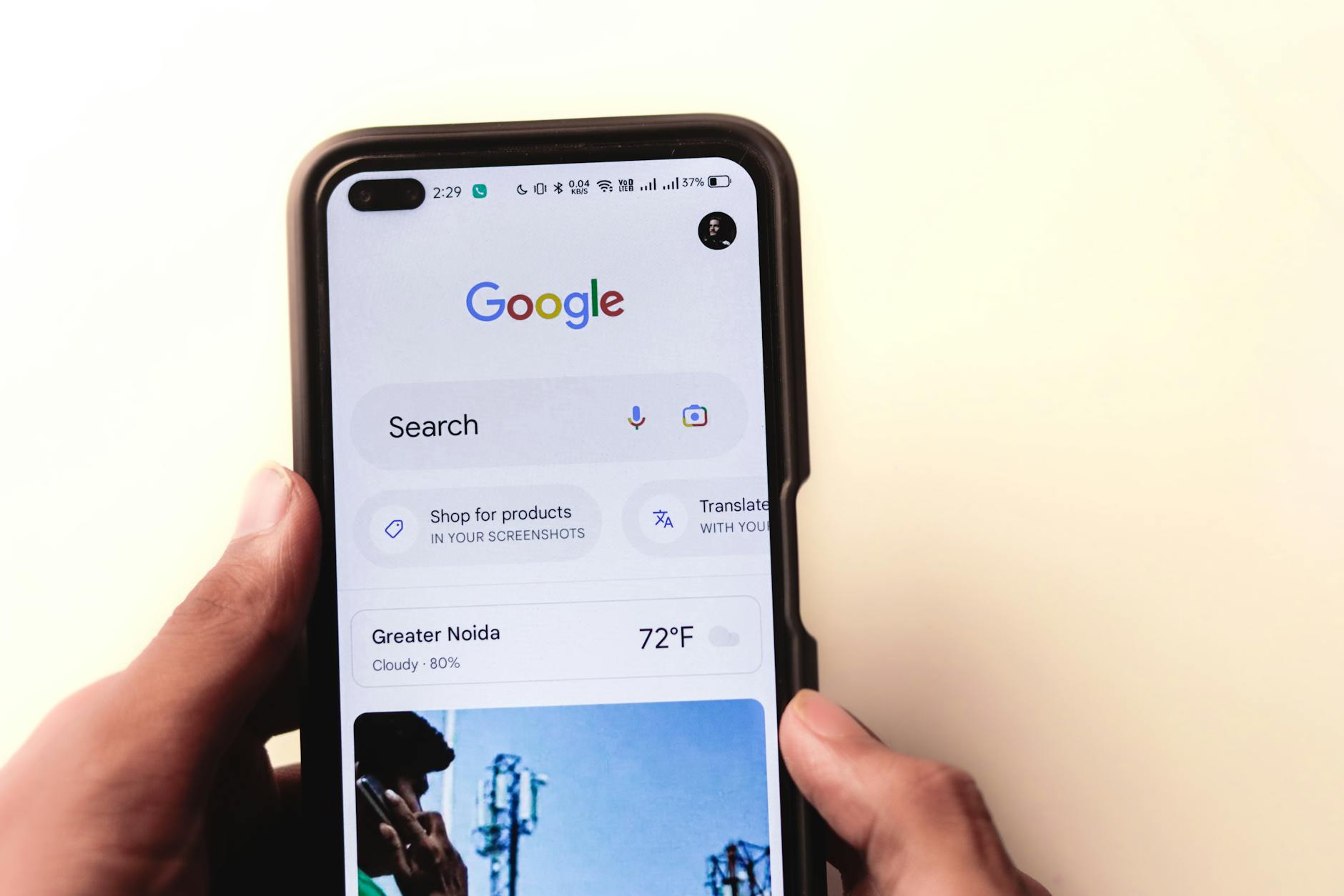 pentingnya SEO website - A close-up of a hand holding a smartphone with Google search displayed on the screen.