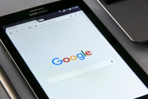 optimasi voice search - Close-up of a tablet displaying Google's search screen, emphasizing technology and internet browsing.
