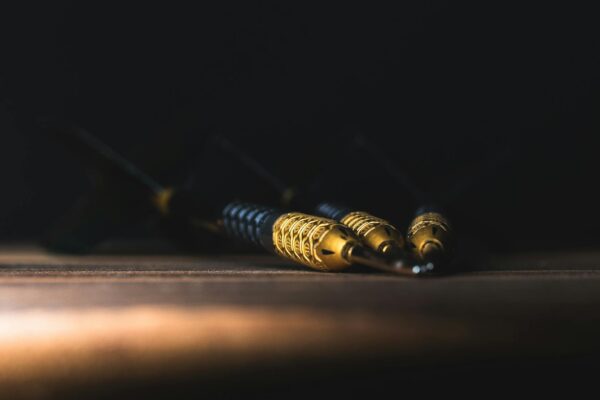 campaign objective adalah - A detailed close-up of darts on a wooden surface in dramatic lighting, showcasing precision and focus.