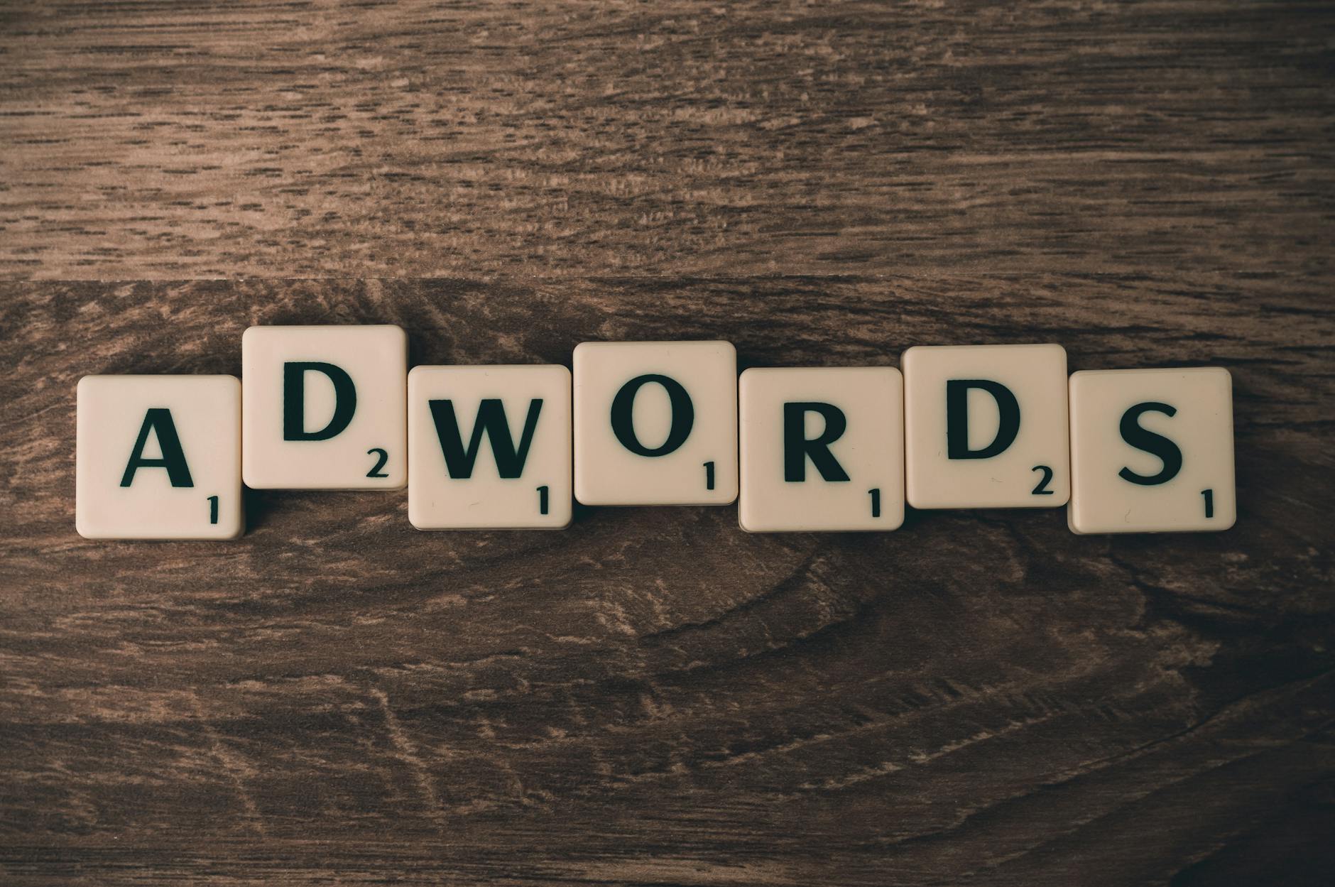 keyword penghasil leads - Scrabble tiles spelling 'AdWords' on a wooden surface, symbolizing digital marketing concepts.