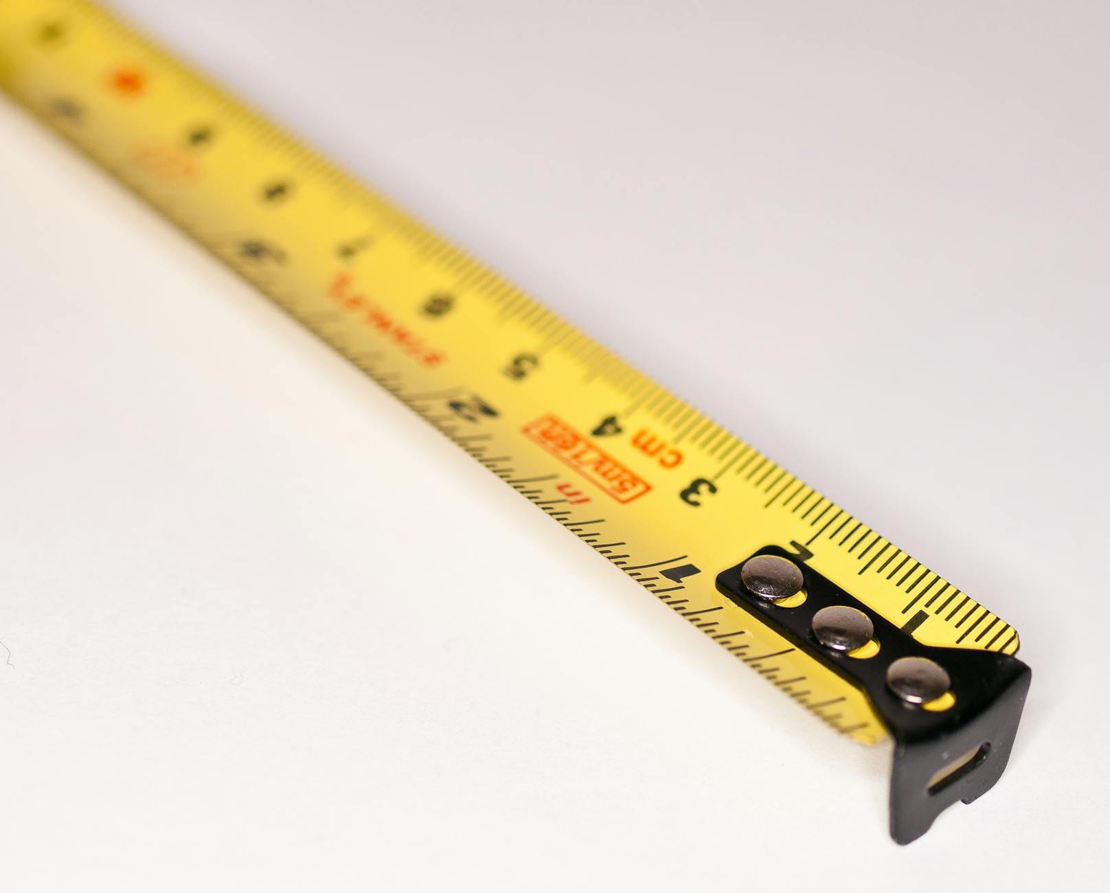 core web vitals metrics - Detailed close-up image of a yellow measuring tape with metric markings.