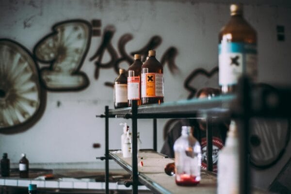 toxic backlink - Discover an abandoned industrial room featuring shelves of toxic chemical bottles and graffiti walls.