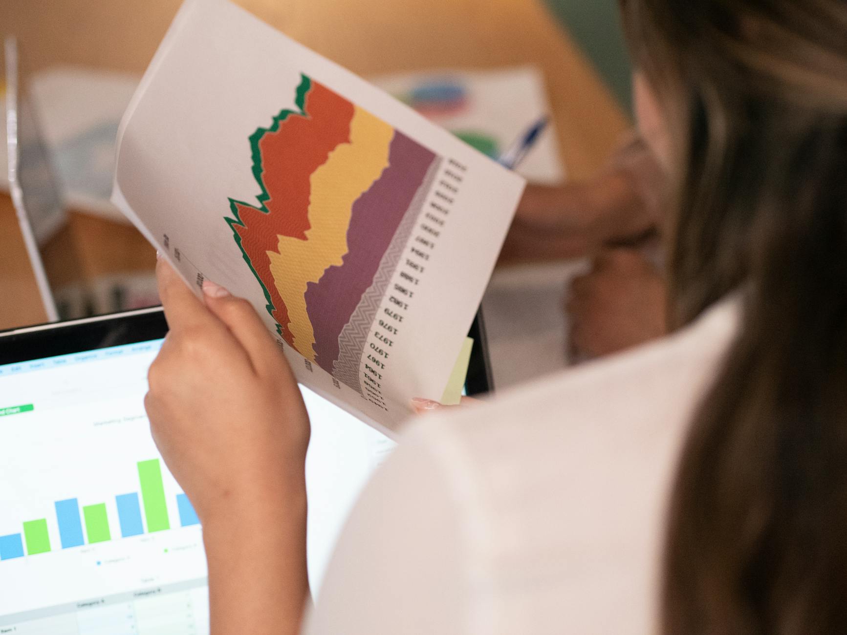 professional seo audit report - Close-up of a woman analyzing colorful charts and graphs in an office setting.