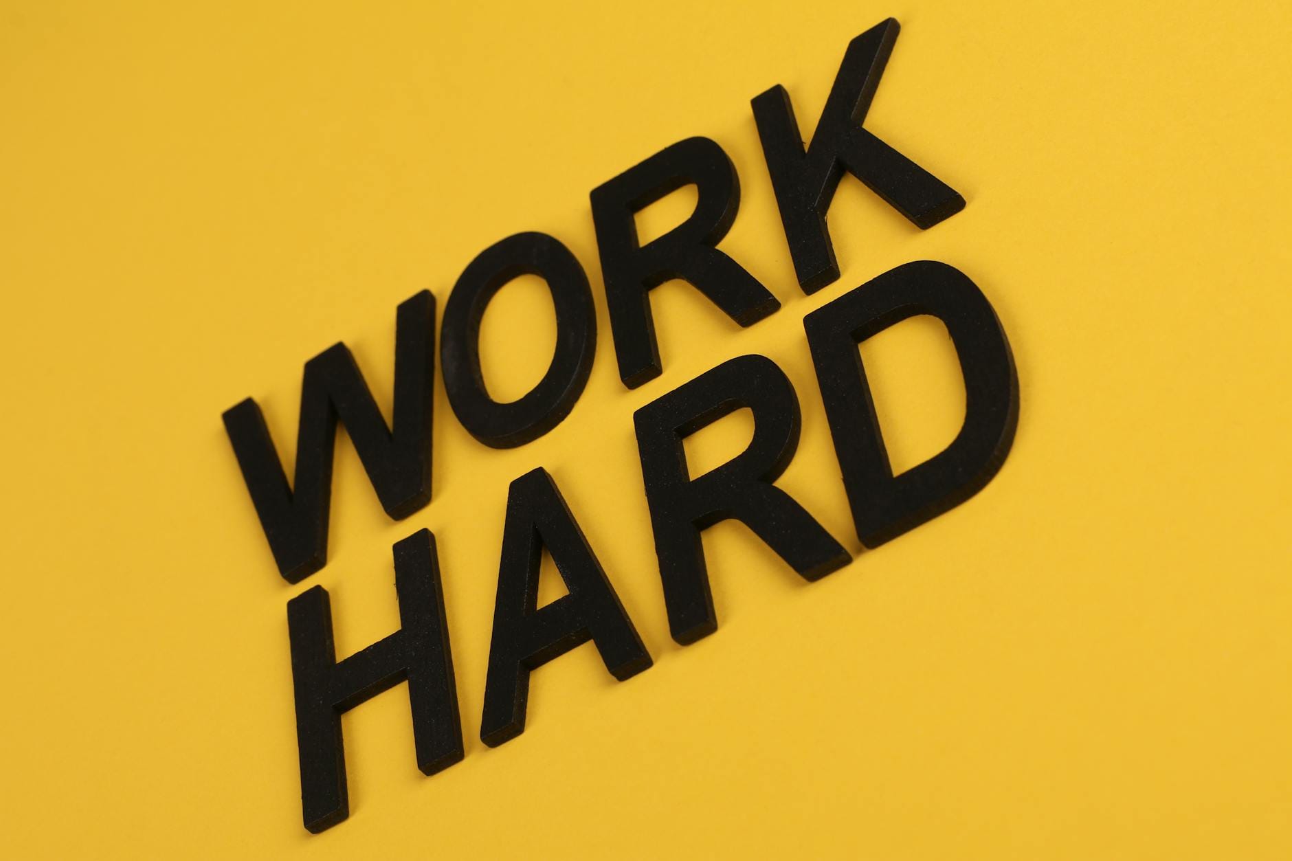 optimize content readability - Black text 'Work Hard' on a vibrant yellow background for motivation.