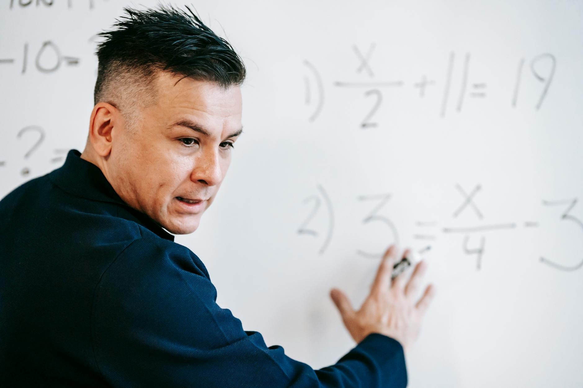 yoast vs rank math - A mathematics instructor explaining algebraic equations on a whiteboard in a classroom setting.